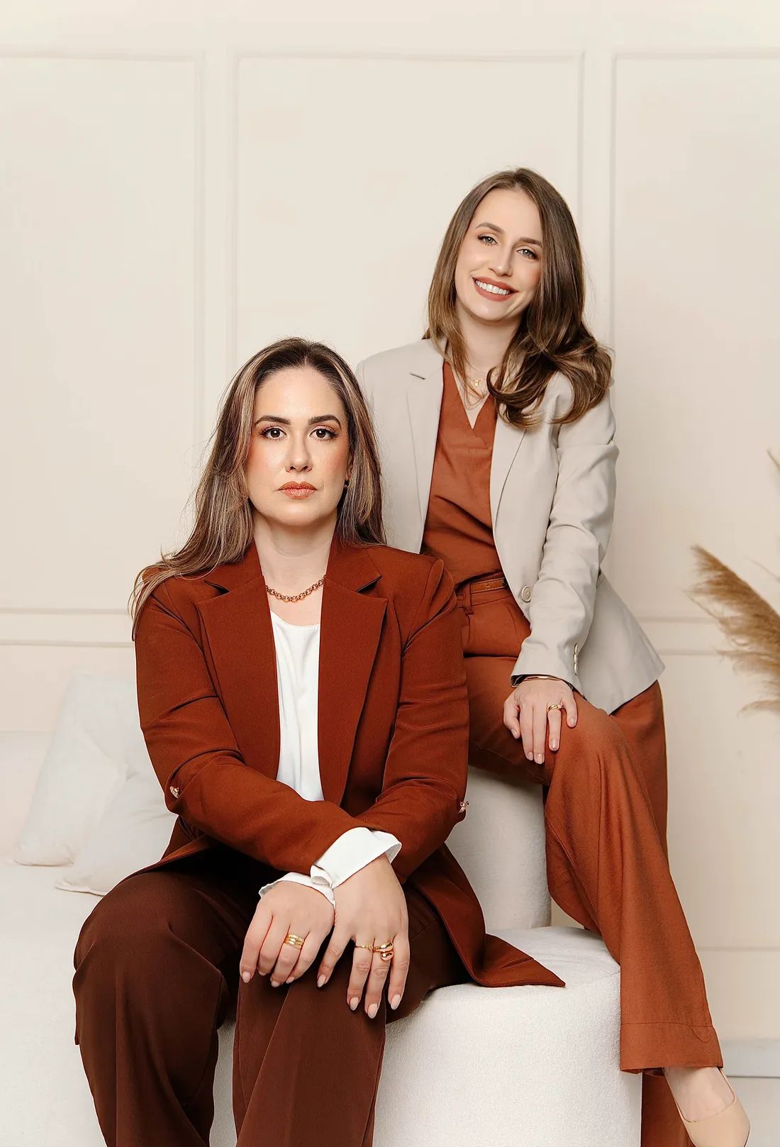 Jenyffer Acorci, sentada, e Jullyana Vanso, apoiada no encosto do sofá: criadoras do Pack de Documentos do Método APP